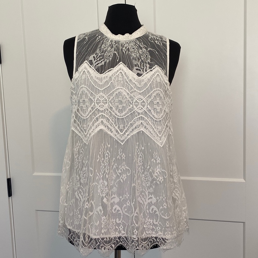 Lacey white sleeveless blouse/shirt, great for work and after.